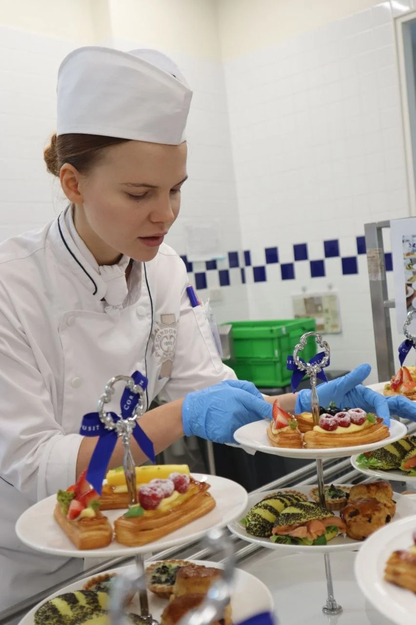 Lina in a chef’s hat arranging pastries